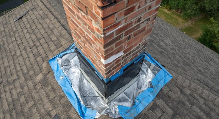 Detailed installation of roof flashing around a chimney in Florida for optimal waterproofing