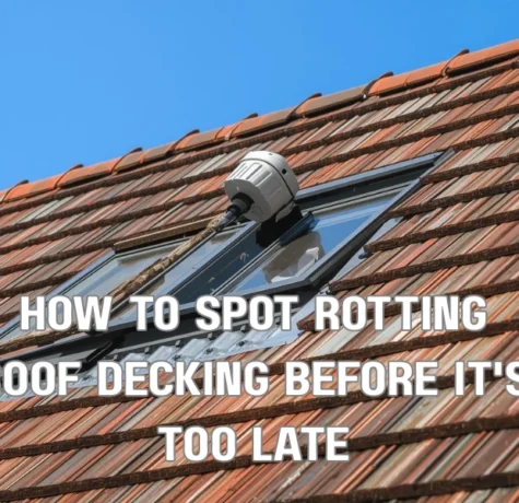 A professional roofing inspector in a dark attic space using a high-powered flashlight and a moisture meter to check the wooden roof decking for signs of structural damage and water stains.