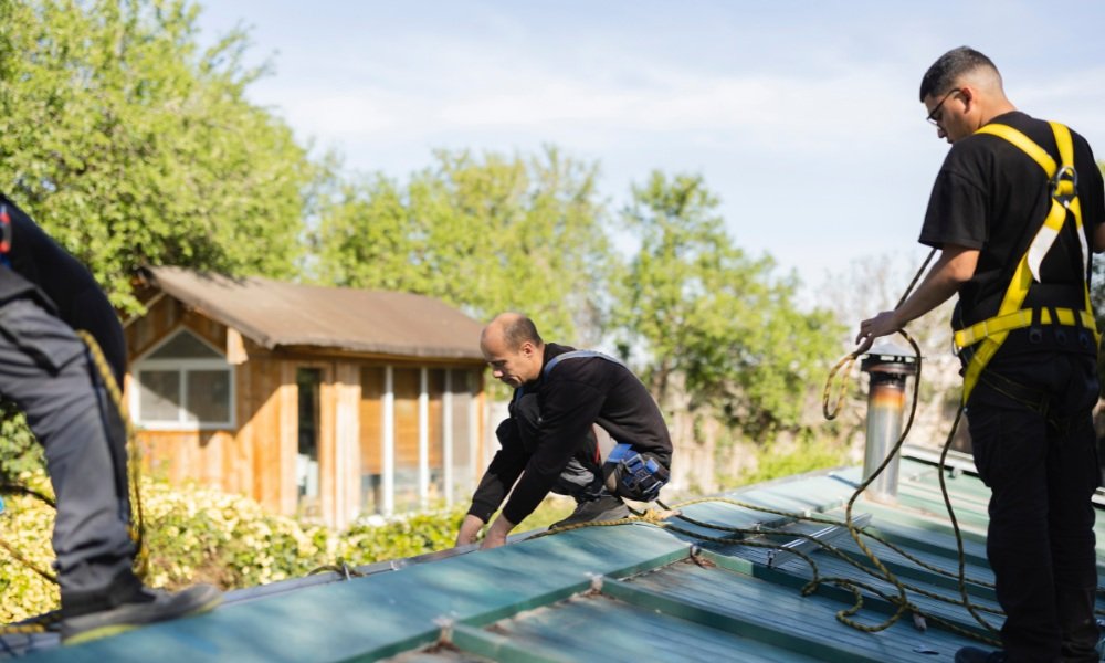 Certified roofing contractor wearing a safety harness and protective gear while working on a residential roof.