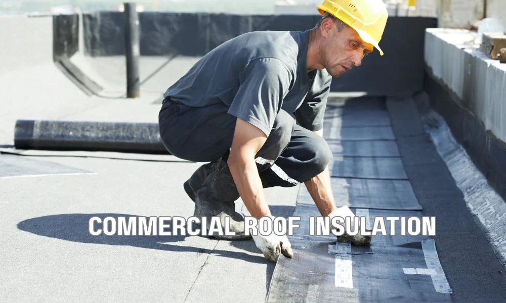 Commercial roofing contractors installing insulation and a waterproof membrane on a flat roof after roof deck preparation during a commercial roof replacement project.
